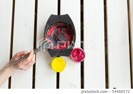 Color and hairdresser concept - female hairdresser in process of mixing hair dye color on the table 54488572