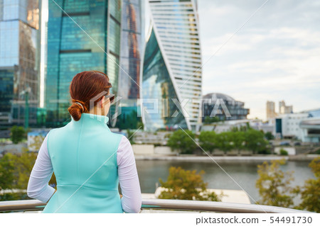Portrait of young woman walking on the street, wearing cute trendy jacket. 54491730