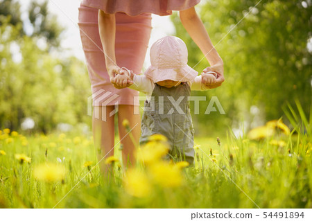 Mother and daughter on a meadow with dandelions Mother and daughter on a meadow with dandelions 54491894