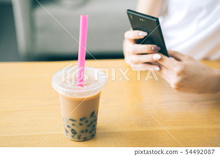 採取與智能手機的少婦的手珍珠粉牛奶茶 54492087