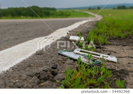 View of a mobile phone lying on the asphalt View of a mobile phone lying on the asphalt 54492366