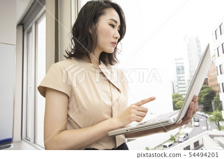 A woman who plays a personal computer at the office 54494201