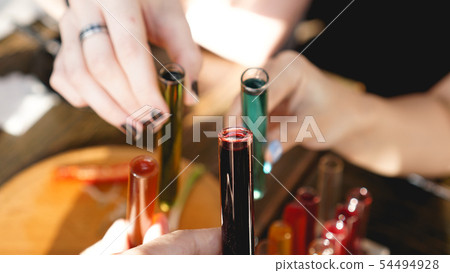 Test tubes with multi-colored liquid. Alcohol in test tubes dark bar Test tubes with multi-colored liquid. Alcohol in test tubes dark bar 54494928
