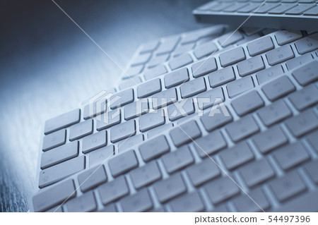 closeup of computer keyboards on a black dark desk closeup of computer keyboards on a black dark desk 54497396
