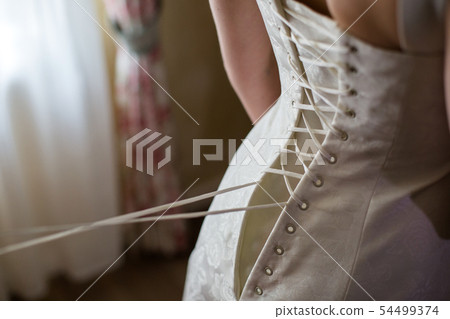 Lacing the wedding dress. 54499374