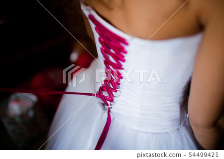 Lacing the wedding dress. 54499421