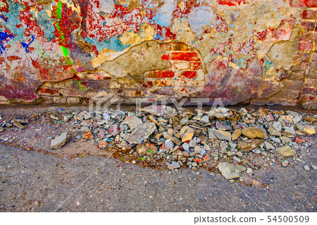 Damaged wall with building garbage beneath 54500509