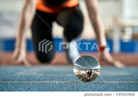 Reflection of sportive woman in glass ball during her running training Reflection of sportive woman in glass ball during her running training 54505408
