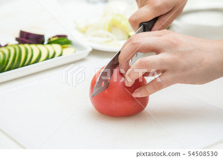 在切與一個切板的背景的黃瓜一個蕃茄在白色背景 在切與一個切板的背景的黃瓜一個蕃茄在白色背景 54508530