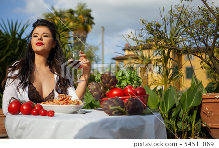 Sexy Italian eats spagetti on the garden terrace 54511069