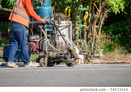Worker wearing uniform is making the white line on Worker wearing uniform is making the white line on 54511424