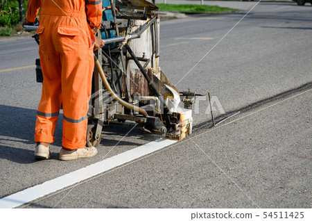 Worker wearing uniform is making the white line on Worker wearing uniform is making the white line on 54511425