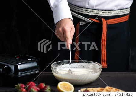 Chef mixing waffle dough in a bowl 54514426