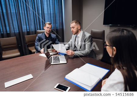 Coworkers meeting at conference room to discuss project in office Coworkers meeting at conference room to discuss project in office 54515686