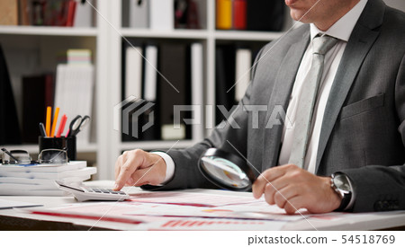 Businessman working and calculating, reads and Businessman working and calculating, reads and 54518769