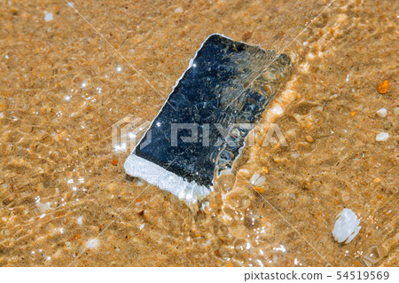 Smart phone with weather on a sandy beach Smart phone with weather on a sandy beach 54519569
