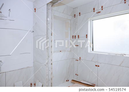 Spreading wet mortar before applying tiles Spreading wet mortar before applying tiles 54519574