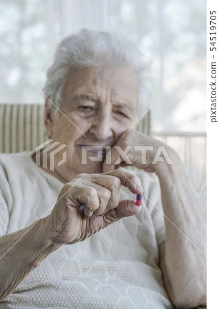 senior woman holding a pill senior woman holding a pill 54519705