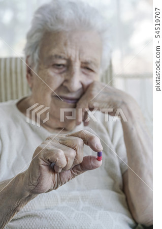 senior woman holding a pill 54519707