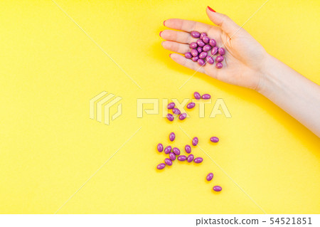 Woman hand holding purple pills handful Woman hand holding purple pills handful 54521851