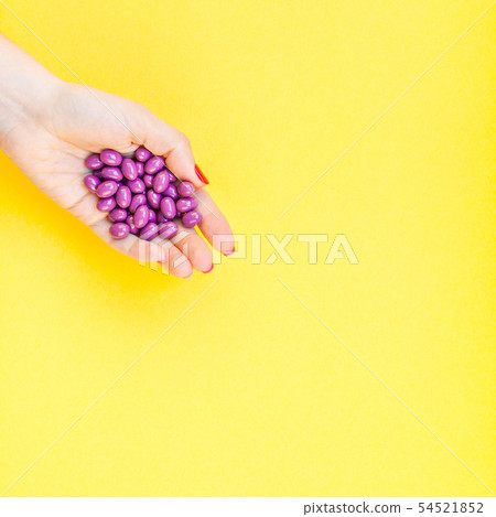 Woman hand holding purple pills handful Woman hand holding purple pills handful 54521852