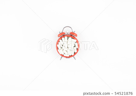 Alarm clock with white pills Alarm clock with white pills 54521876