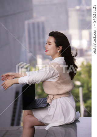 A woman with a laptop on her lap 54523125