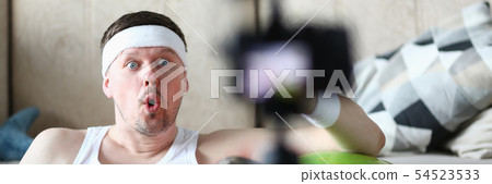 Male vlogger holds dumbbells in his 54523533