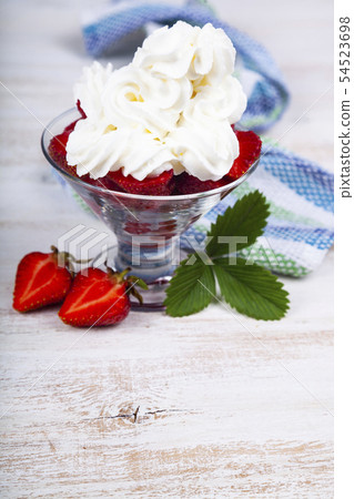 Strawberries and cream in a transparent bowl 54523698