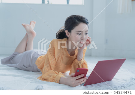 看智能手機和個人計算機的婦女 看智能手機和個人計算機的婦女 54524471