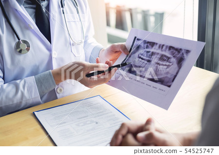 Dental hygienist demonstrating and showing a dummy 54525747