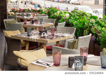 Summer terrace cafe, restaurant. Tables chairs neatly arranged and arranged to serve guests. Summer terrace cafe, restaurant. Tables chairs neatly arranged and arranged to serve guests. 54528064