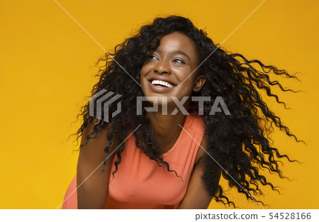 Young african woman laughing on yellow background Young african woman laughing on yellow background 54528166