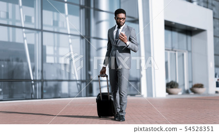 Afro Businessman Using Phone, Arriving at Airport 54528351