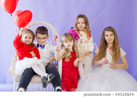 Boy and girls sit together with red balloons 54528924