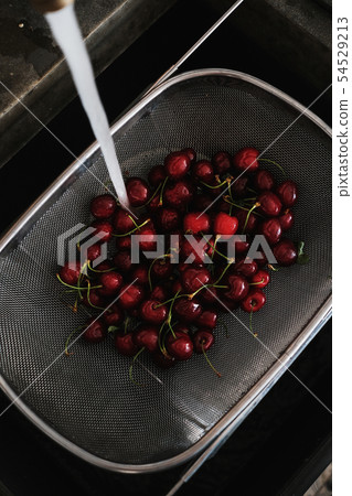 Fresh garden cherries being washed in strainer Fresh garden cherries being washed in strainer 54529213