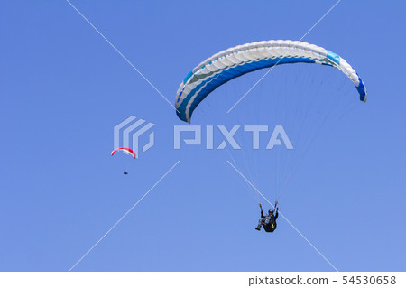 Paragliding in the blue sky as background extreme Paragliding in the blue sky as background extreme 54530658