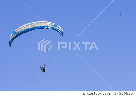 Paragliding in the blue sky as background extreme Paragliding in the blue sky as background extreme 54530659