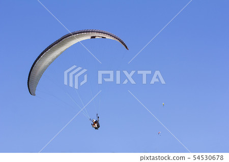 Paragliding in the blue sky as background extreme Paragliding in the blue sky as background extreme 54530678