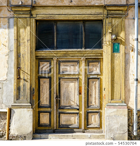 an old interesting three-piece wooden door in an old interesting three-piece wooden door in 54530704