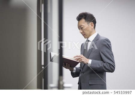 Middle-aged businessman reading books Middle-aged businessman reading books 54533997