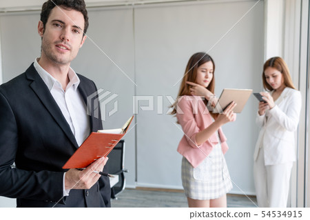 Businessman reading book in business office . 54534915