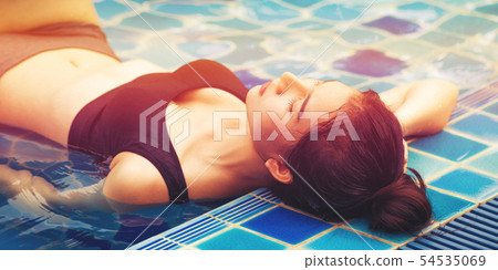 Woman at swimming pool in summer in luxury resort. 54535069