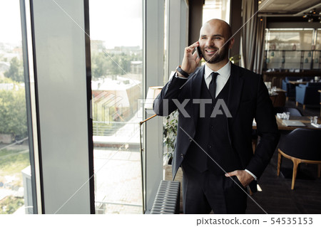 Close up of handsome businessman, working on laptop in restaurant 54535153