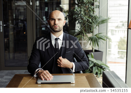 Close up of handsome businessman, working on laptop in restaurant 54535155