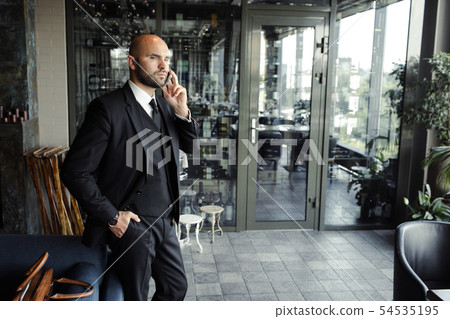 Close up of handsome businessman, working on laptop in restaurant Close up of handsome businessman, working on laptop in restaurant 54535195