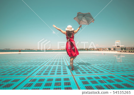 Happy woman traveler dances on outdoor floor. Happy woman traveler dances on outdoor floor. 54535265