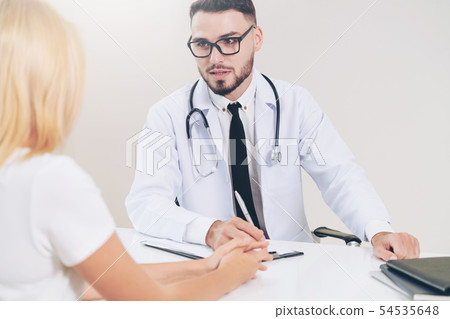 Male Doctor and Female Patient in Hospital Office 54535648