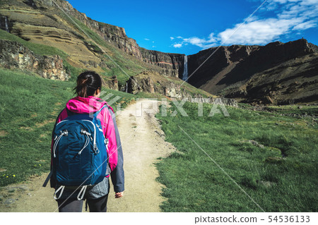 Traveler hiking at Hengifoss Waterfall, Iceland. Traveler hiking at Hengifoss Waterfall, Iceland. 54536133