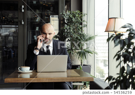 Close up of handsome businessman, working on laptop in restaurant 54536259